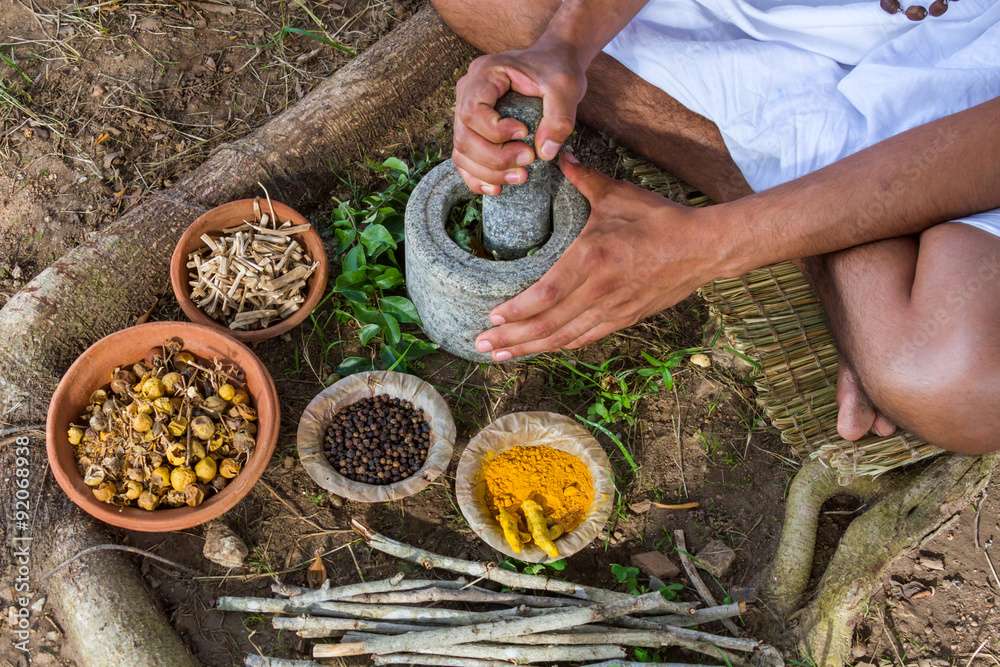 A young man preparing traditional Ayurvedic medicine in India.