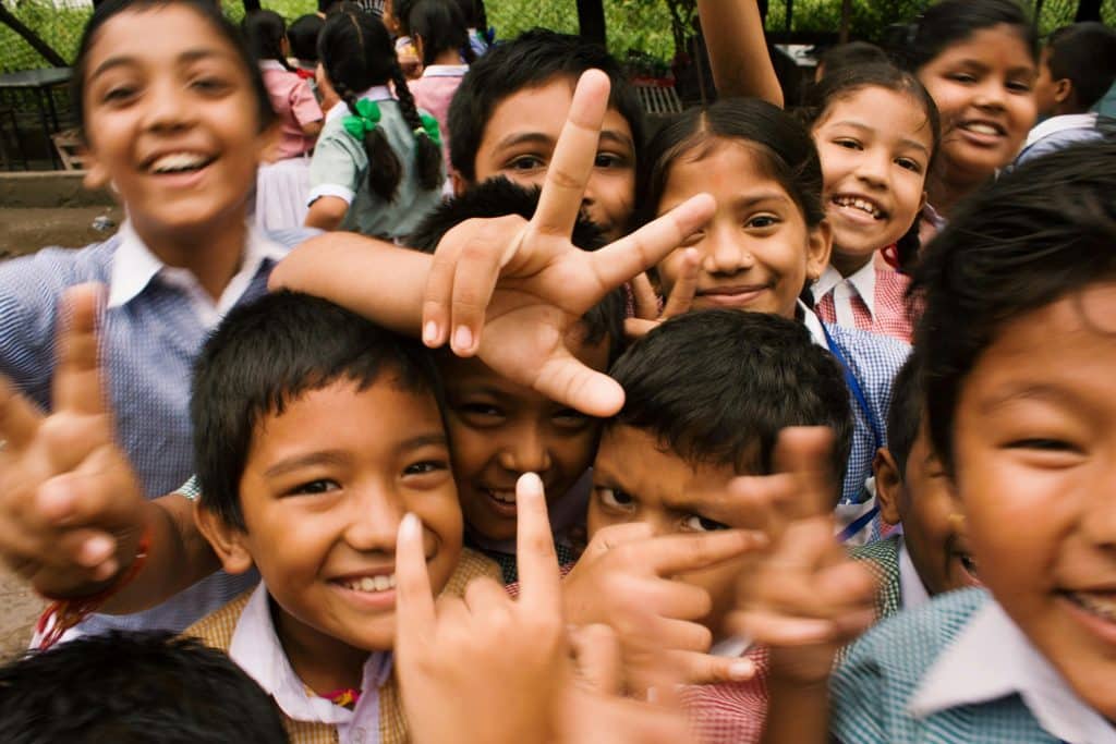pexels-photo-764681-764681 A joyful group of children smiling and making playful gestures outdoors in Namarjung, Nepal.