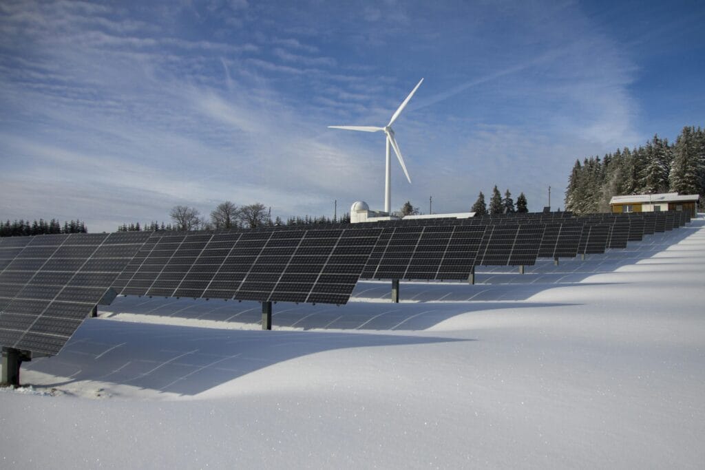 pexels-photo-433308-433308 Solar panels and wind turbine in a snowy landscape, showcasing renewable energy sources.
