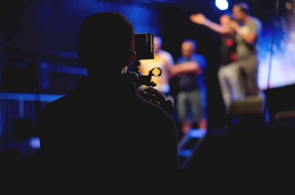 pexels-photo-1870438-1870438 A cameraman films a live concert performance, capturing the dynamic stage action.