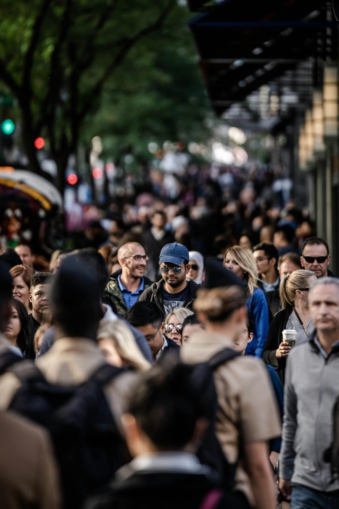 pexels-photo-1687093-1687093 A bustling urban scene with diverse people walking on a tree-lined city street.